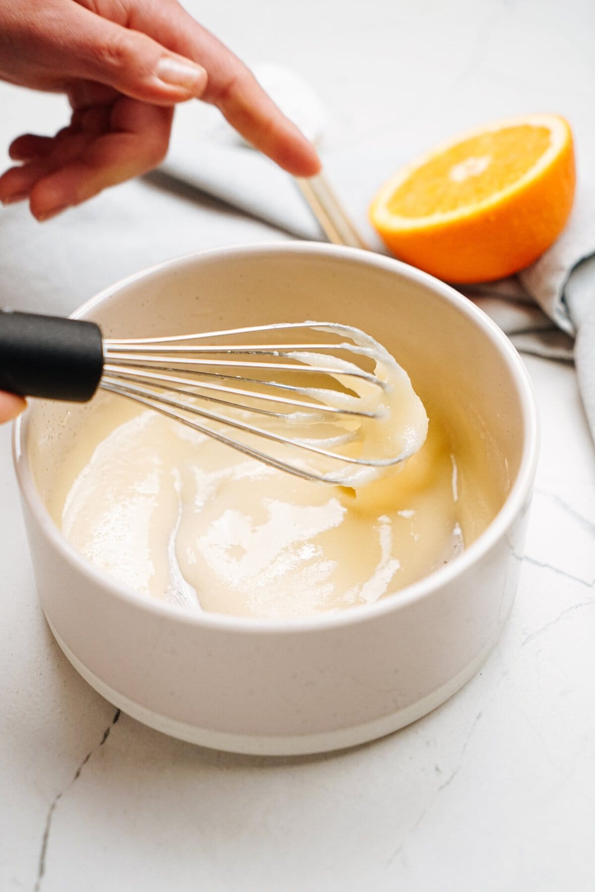 a person whisking glaze together in a bowl