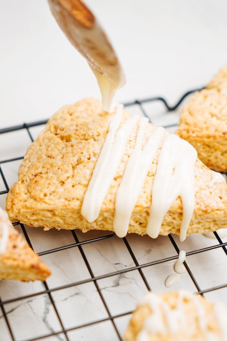 glaze being drizzled over a scone