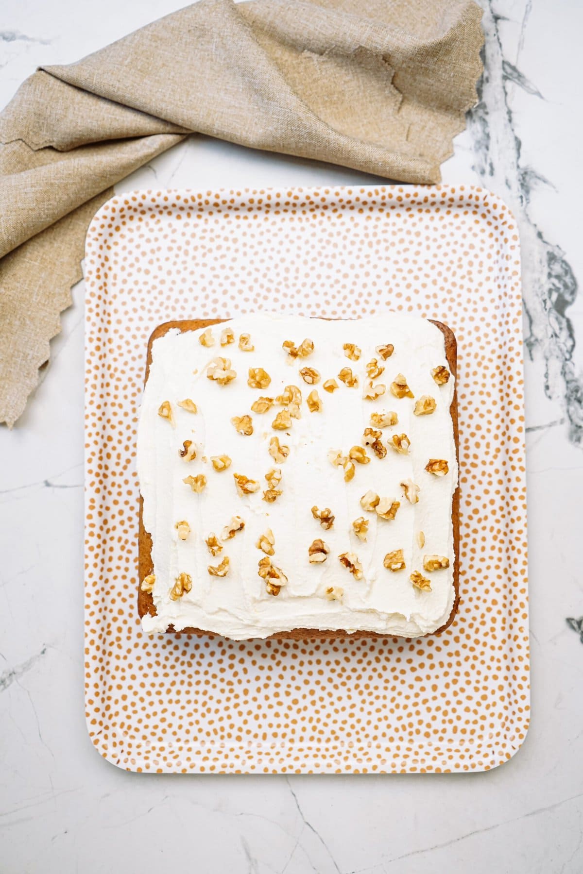 banana cake on a cutting board with walnuts sprinkled on top 