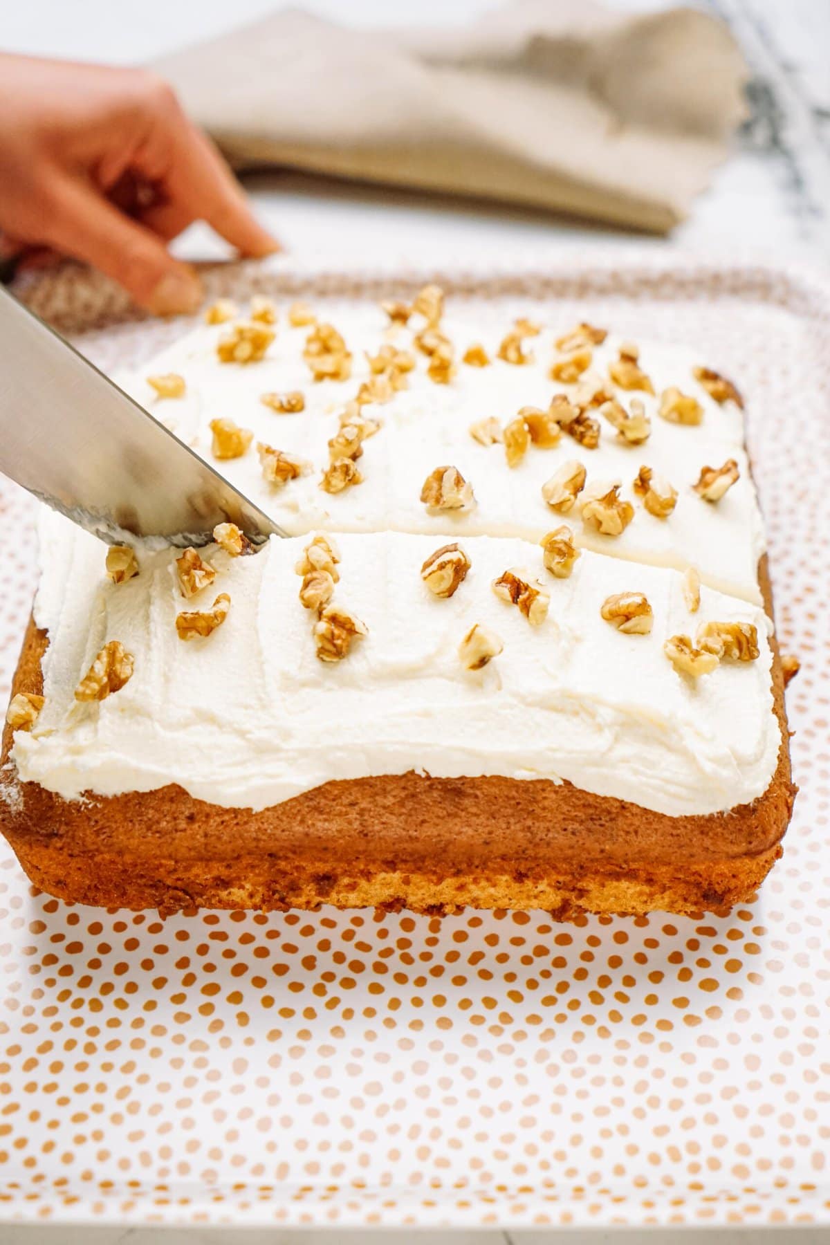 a person cutting banana cake into squares 