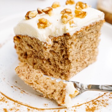 a piece of banana cake on a plate with a bite of cake on a fork
