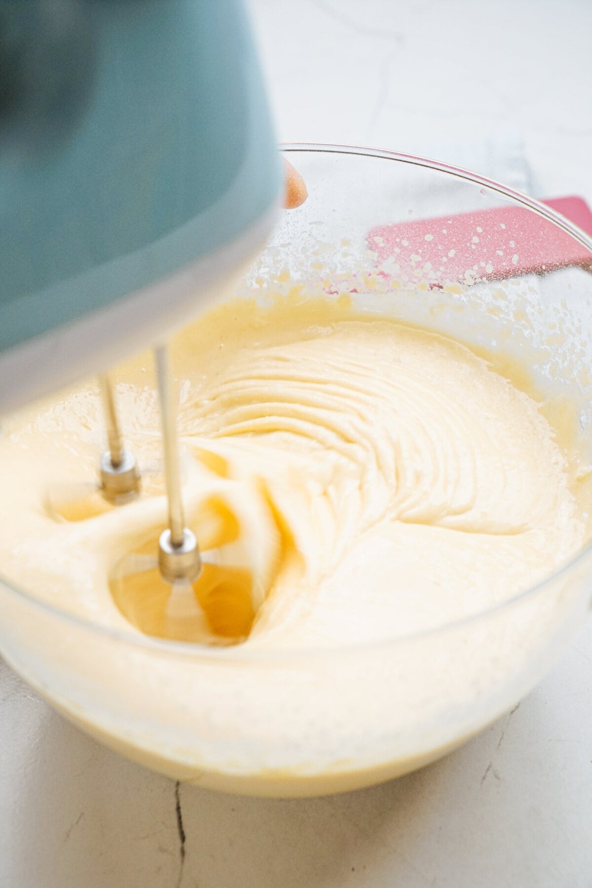 vanilla cake batter being whisked with an electric mixer