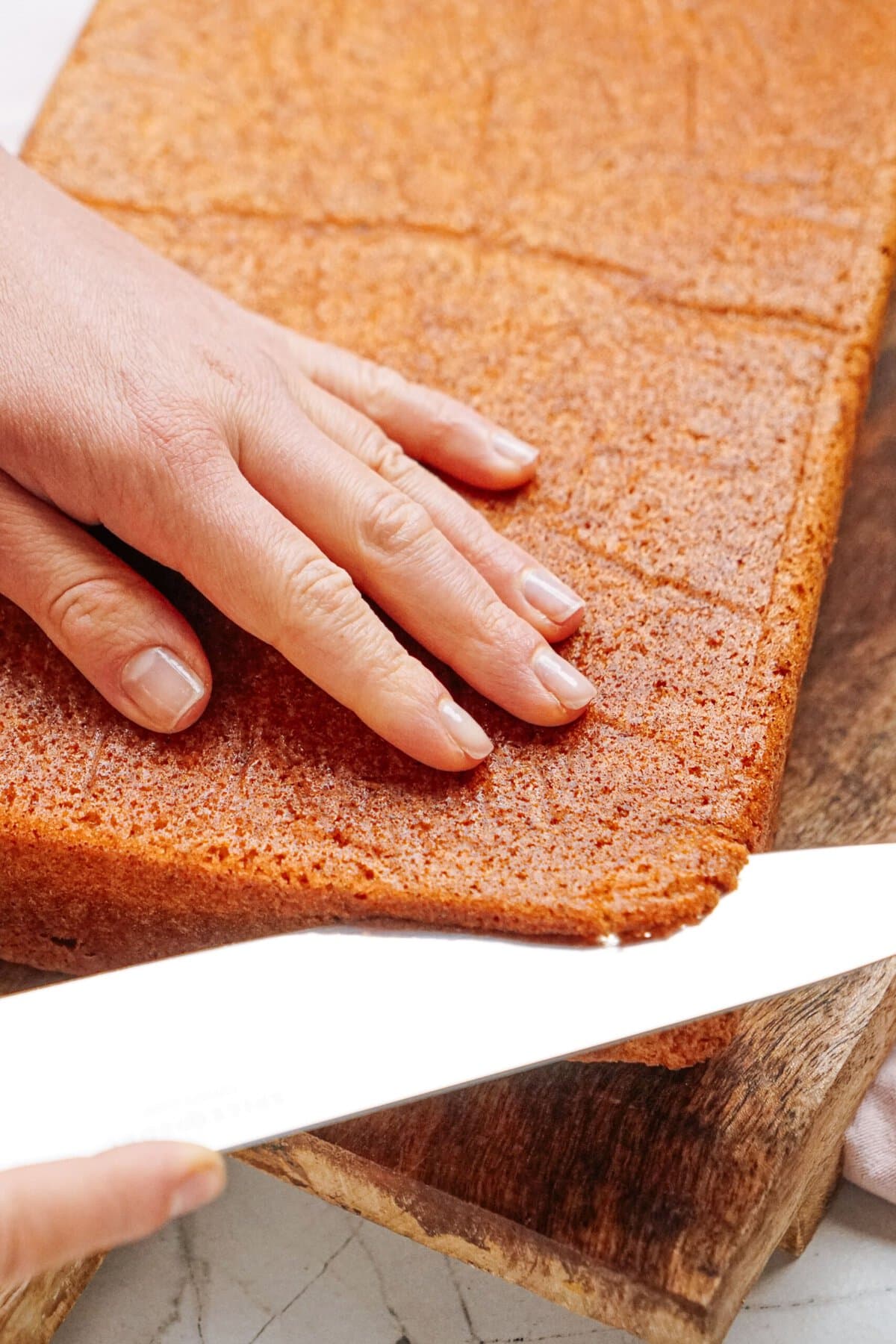 a person removing the browned layer of cake 