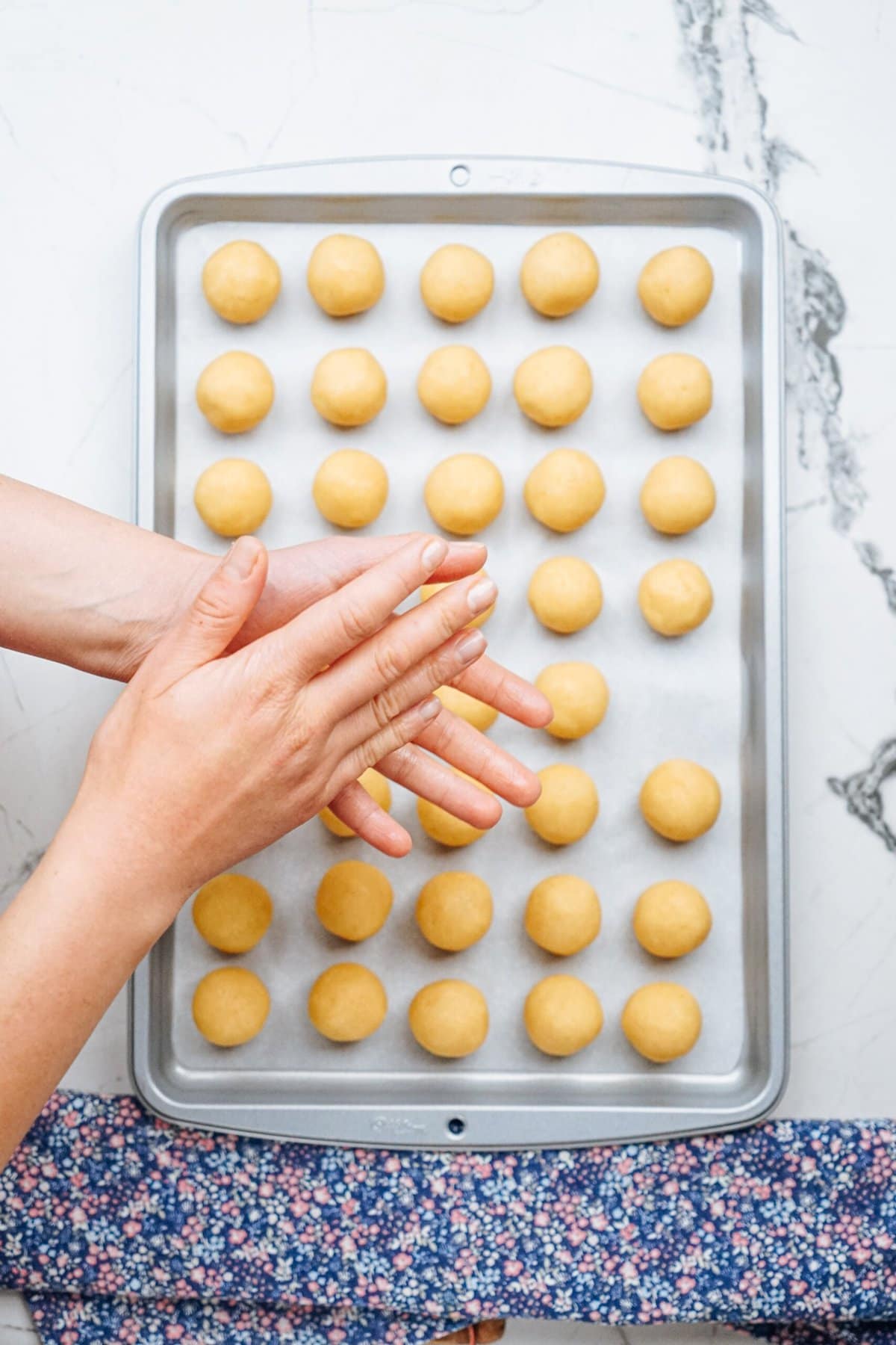 a person rolling each cake ball in her palms of there hands