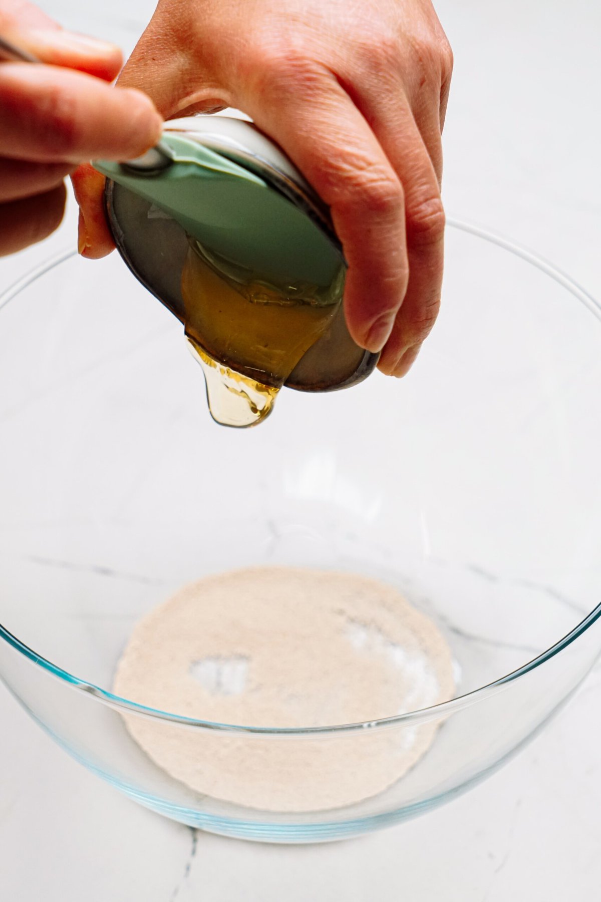 a person adding honey into a bowl