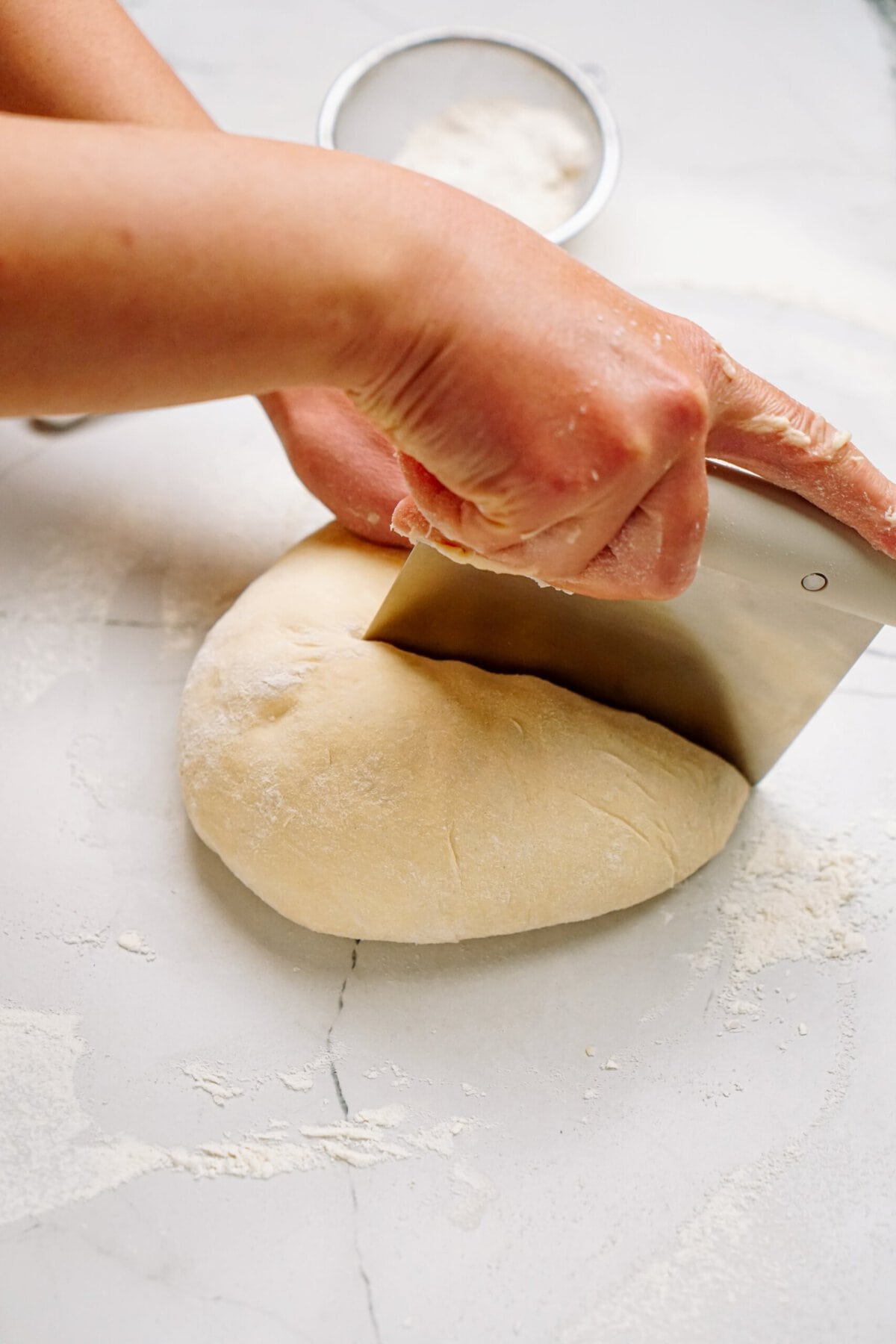 a person dividing out dough