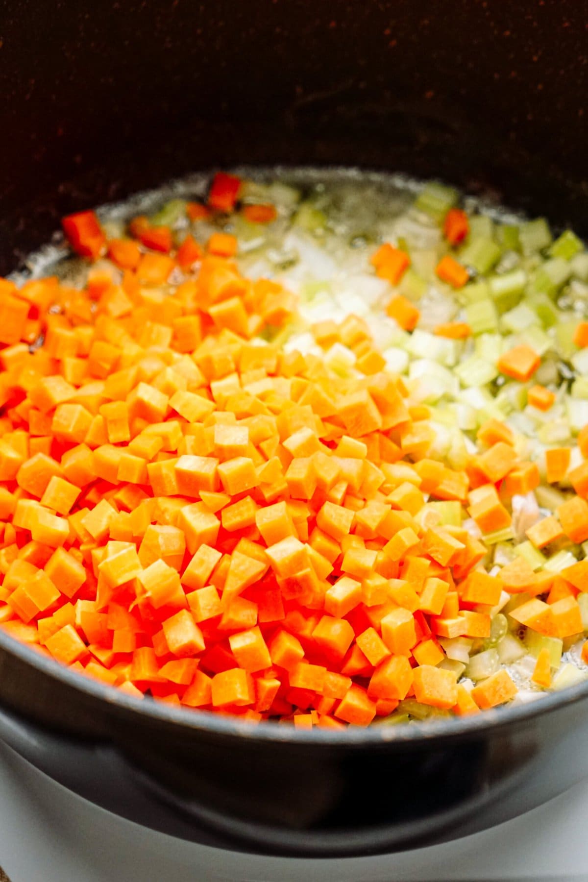 carrots and celery sautéing in a skillet 