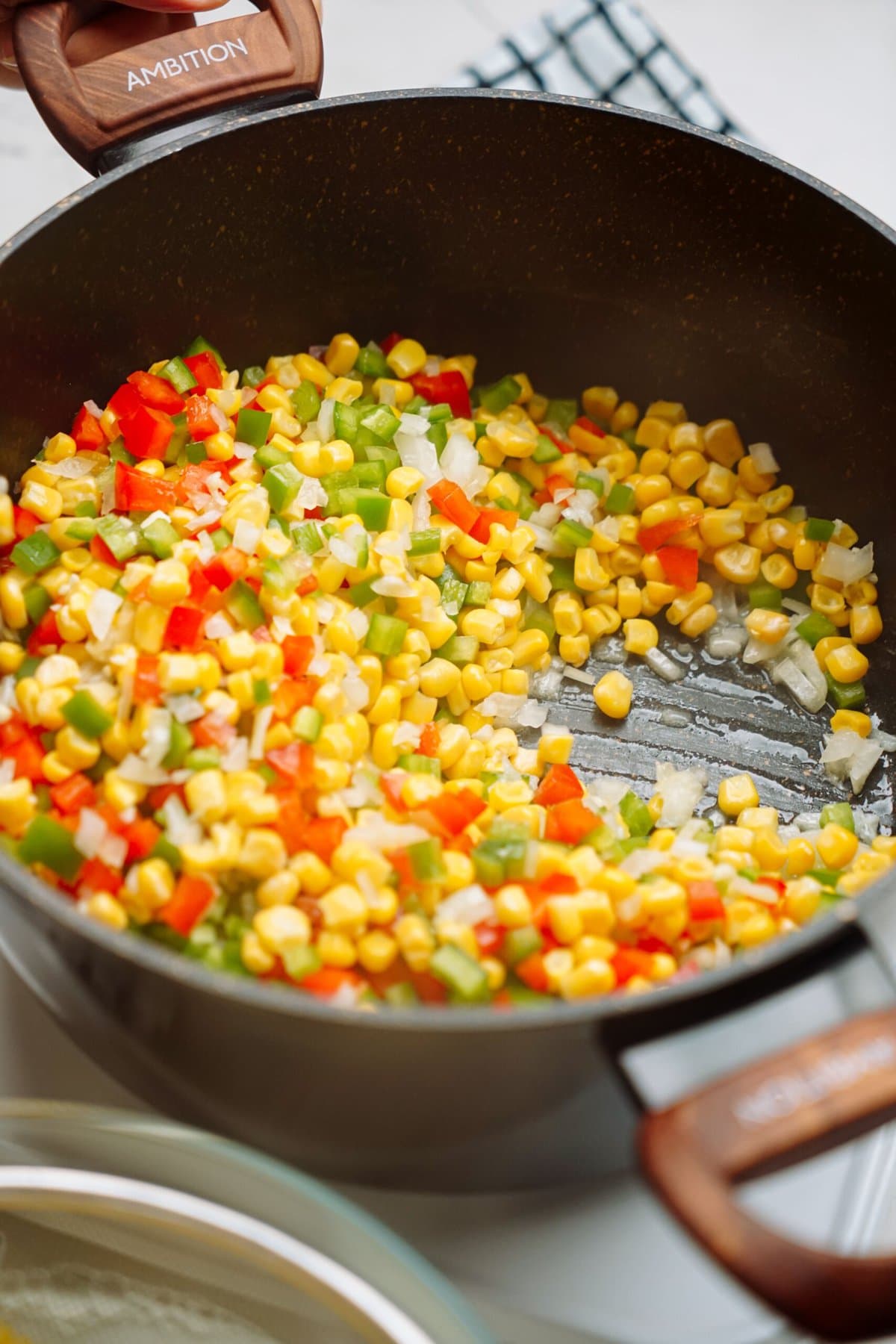 corn and peppers sautéing in a pot 