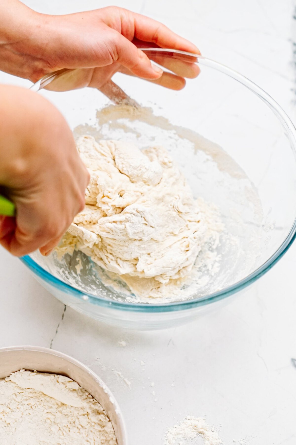 a person mixing dough ingredients together 