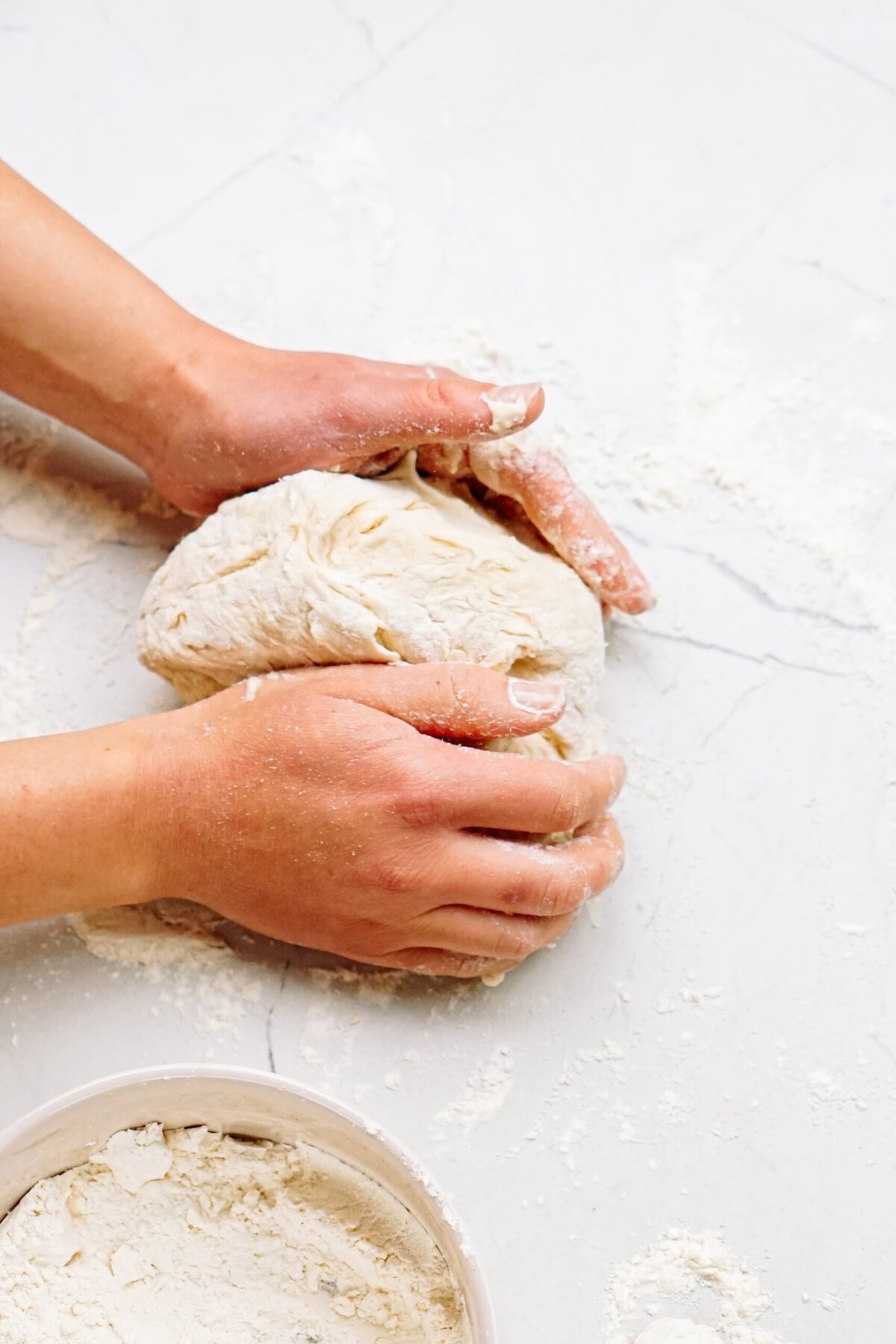 a person kneading dough 