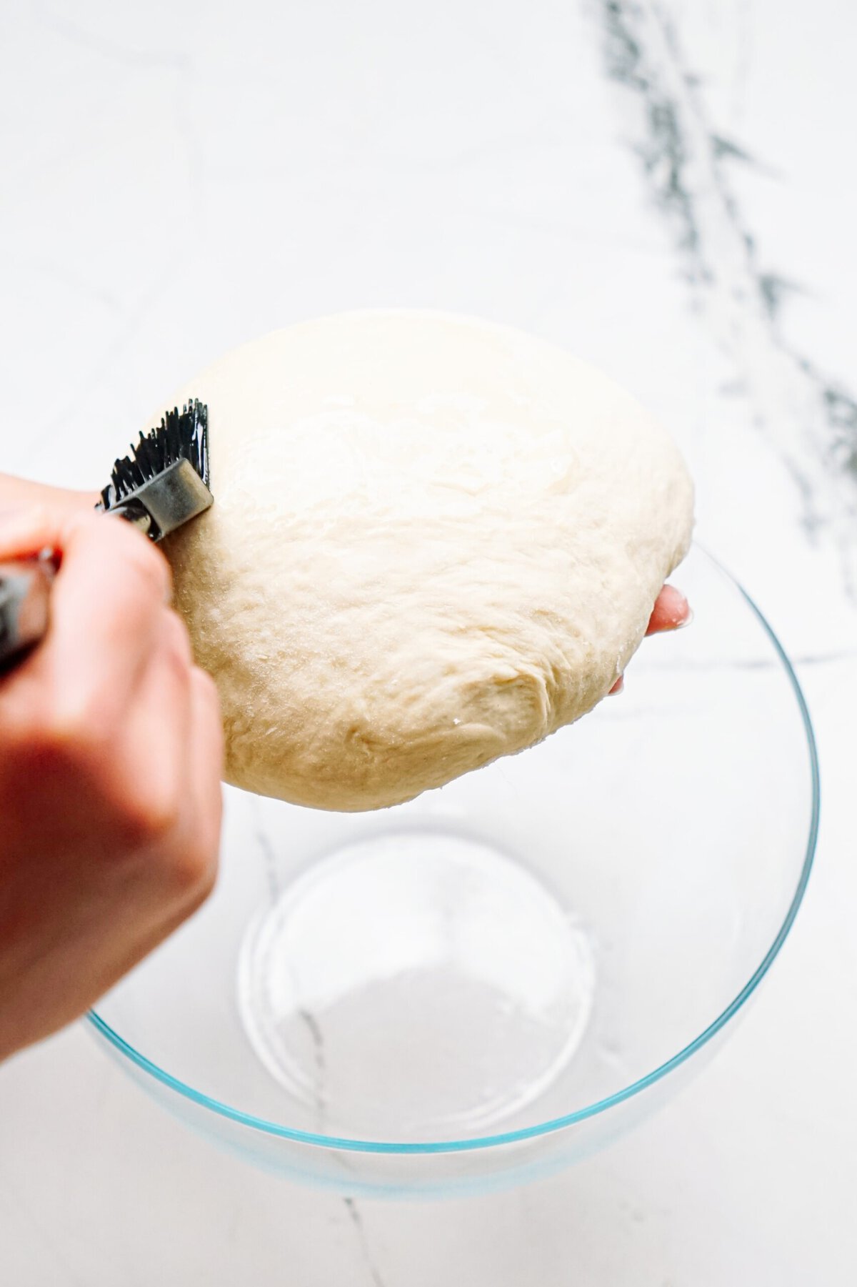 a person brushing melted butter on to the dough 