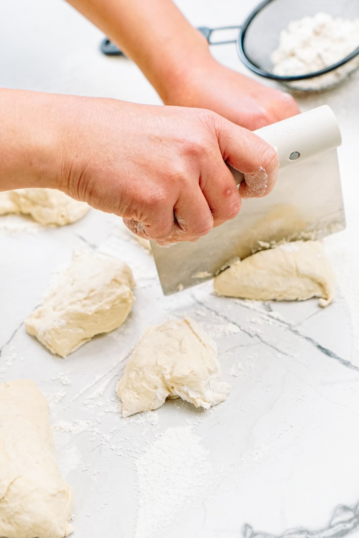 a person cutting dough into small pieces