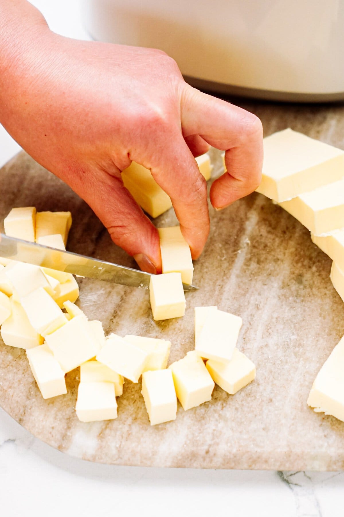 a person cutting butter into cubes