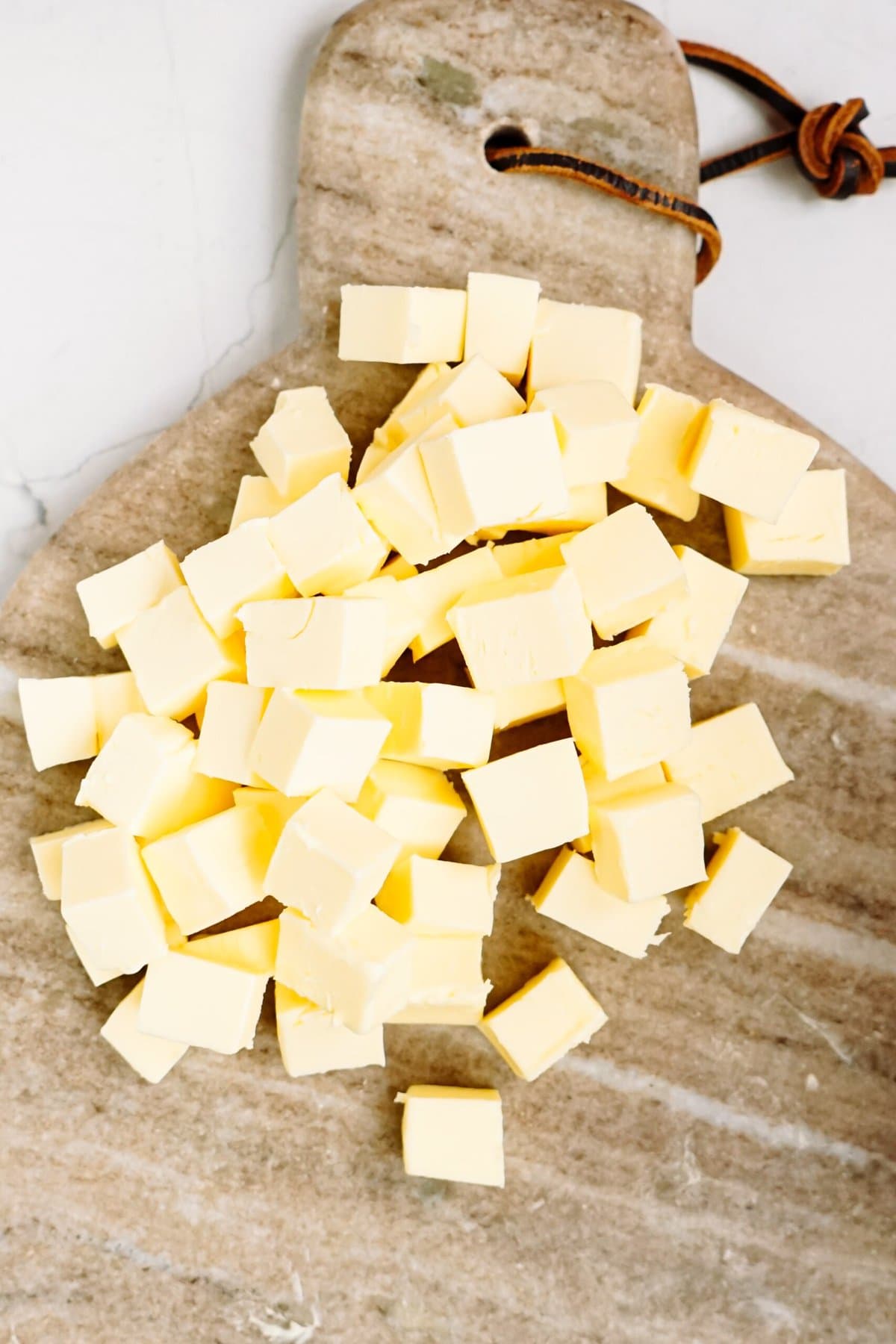 cubed butter on a wooden cutting board