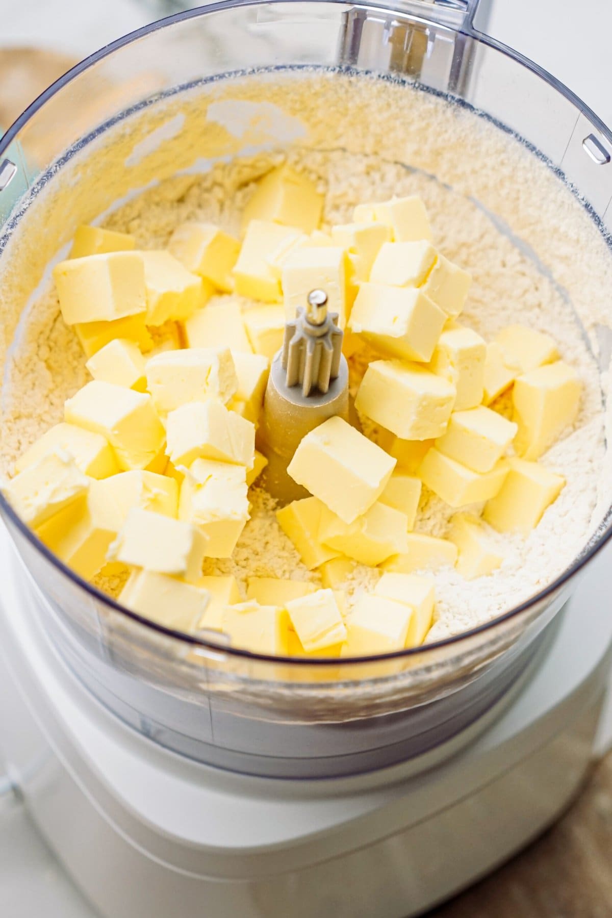 cubes of butter added to the food processor with flour mixture