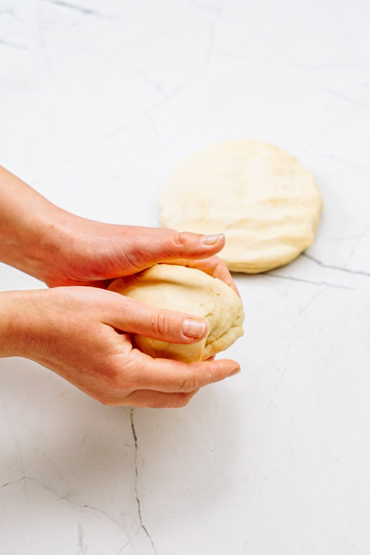 a person forming the dough into 2 halves