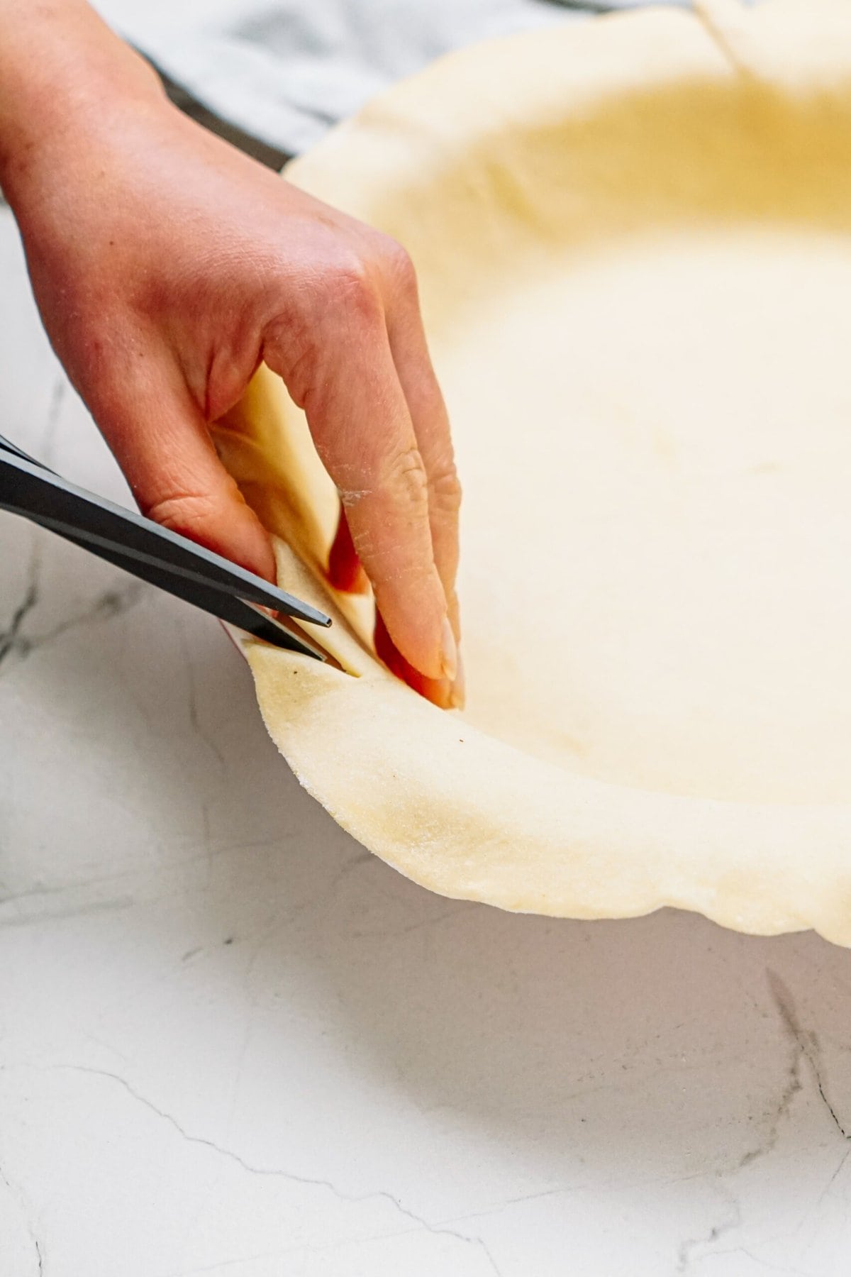 cutting the excess dough off with kitchen sheers
