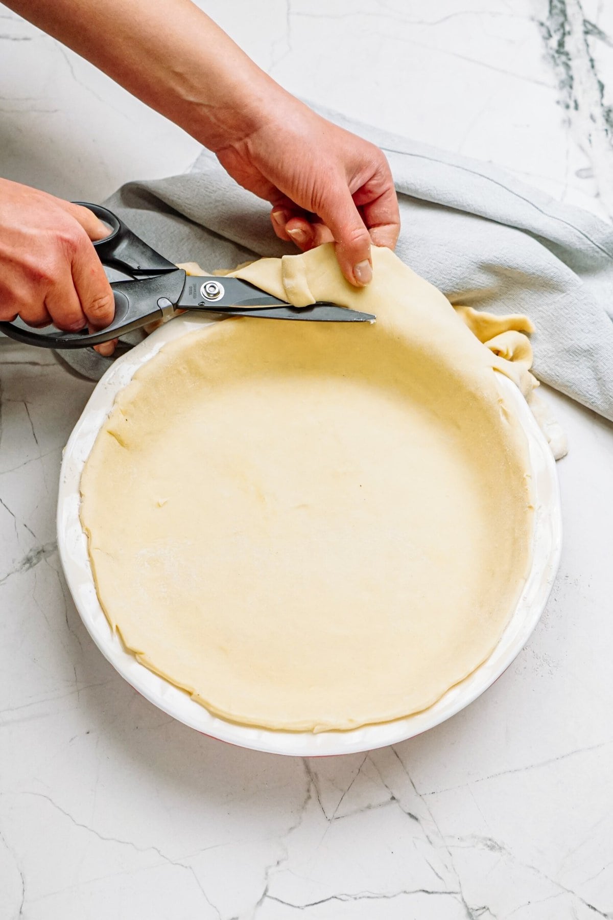 cutting off excess dough with kitchen sheers