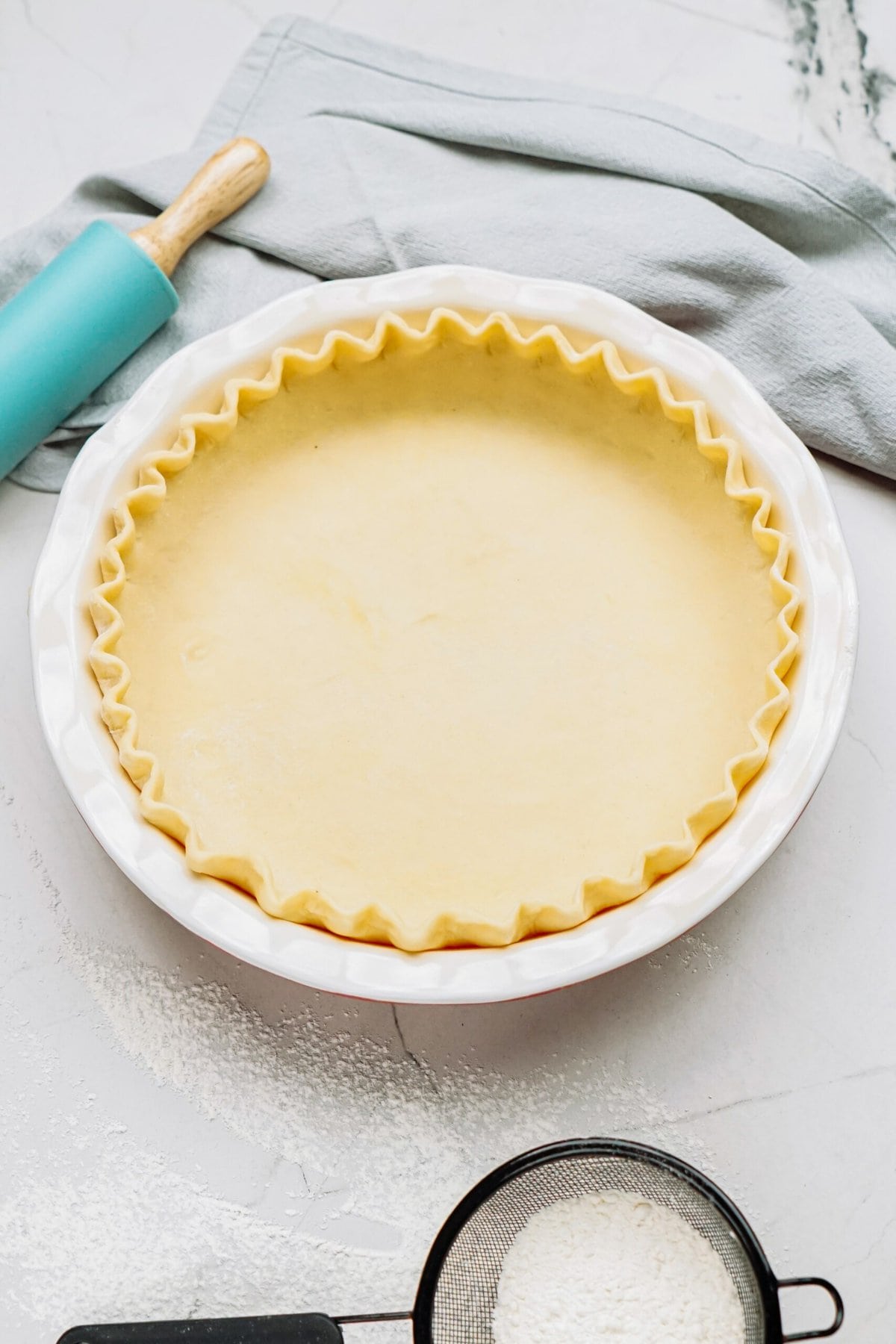 butter pie crust in a pie plate on a tablescape 