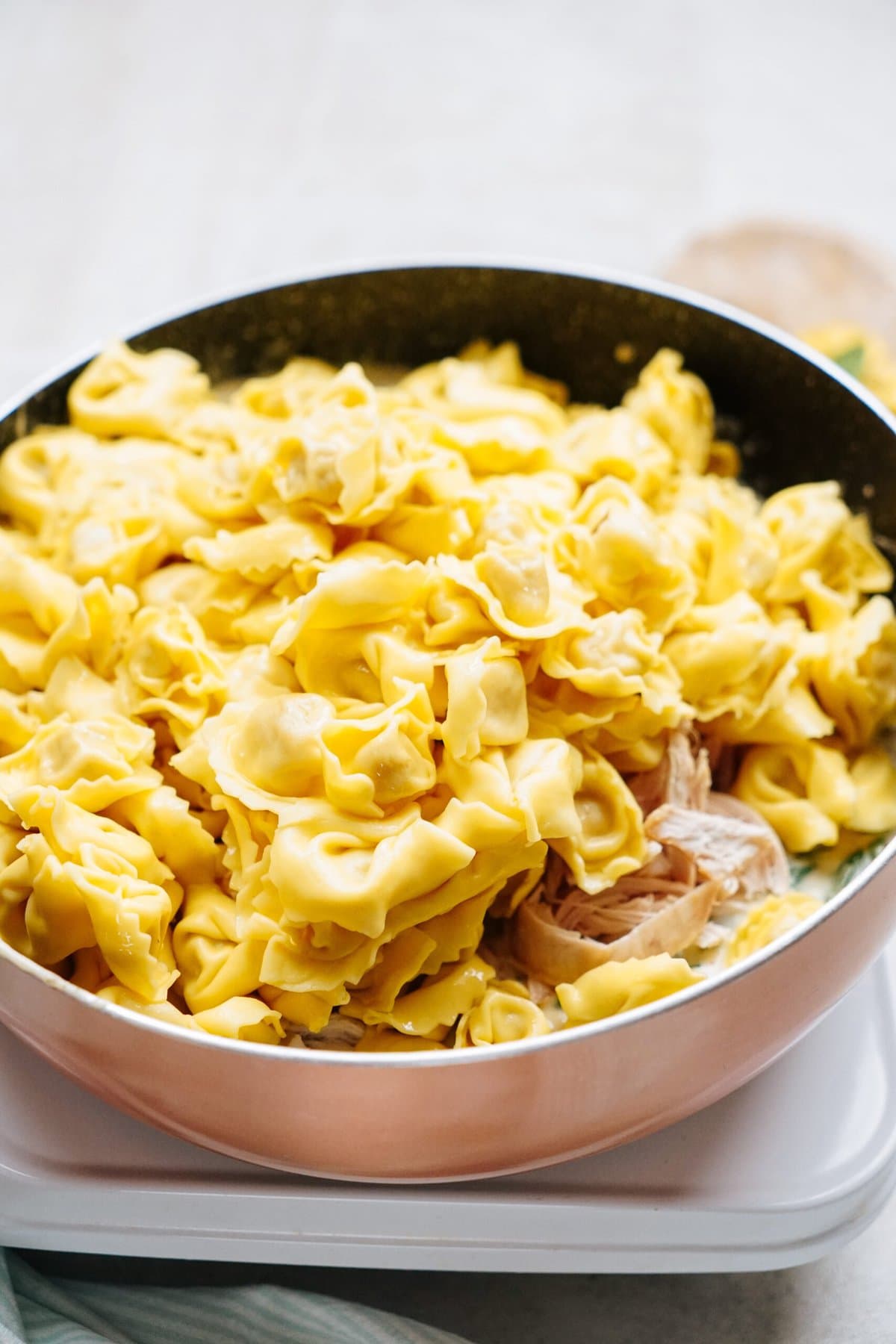 A pan filled with cooked tortellini pasta.