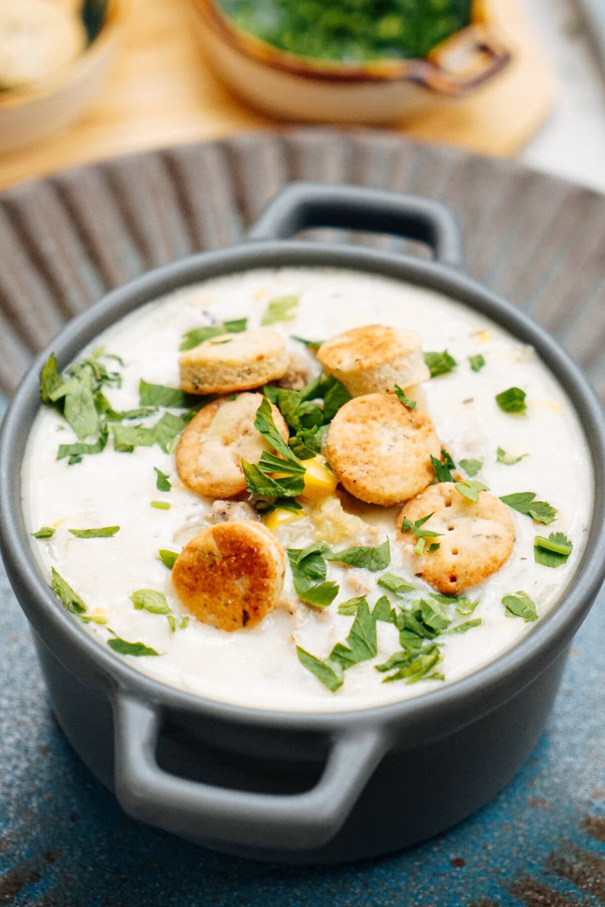 sausage corn chowder in small pot with crackers