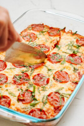 A Zucchini Pizza Casserole with pepperoni and cheese in a glass dish.