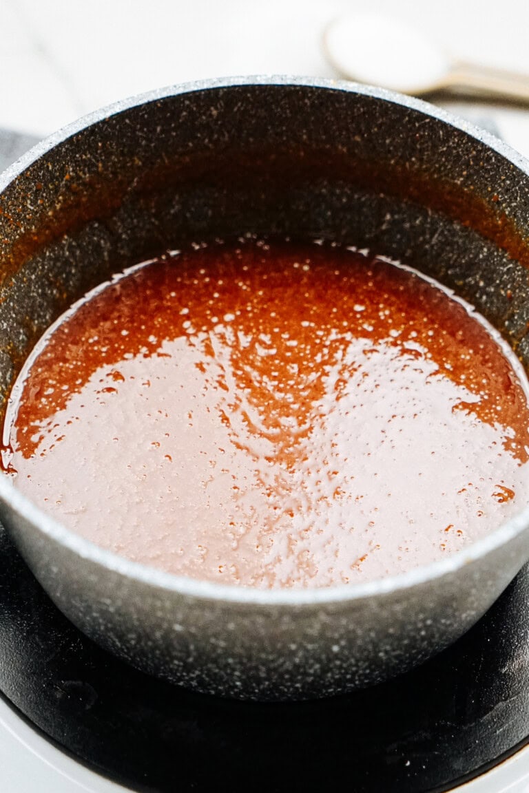 A close-up of a pot filled with a caramel sauce.