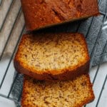 Sliced banana bread on a wire cooling rack with visible banana specks.