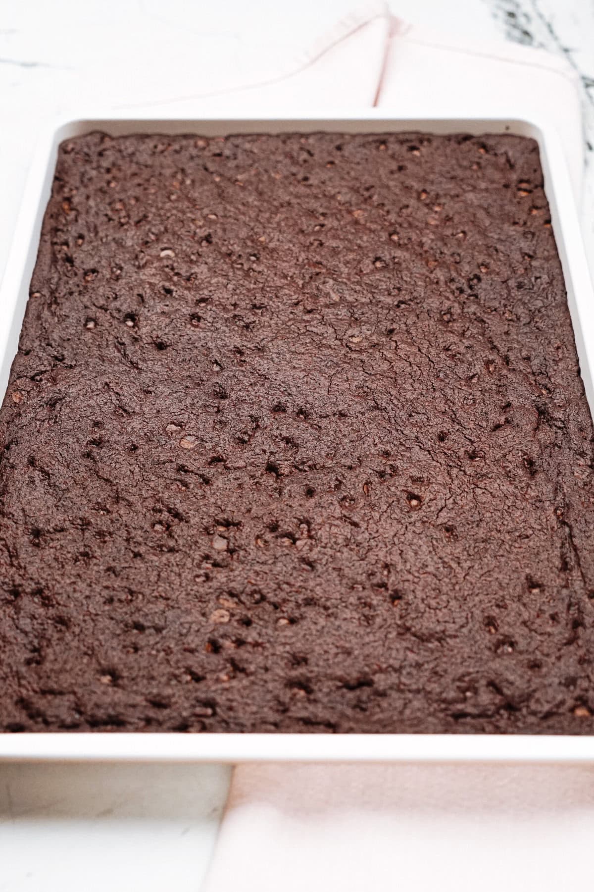 A tray of freshly baked chocolate brownies with a textured top surface.