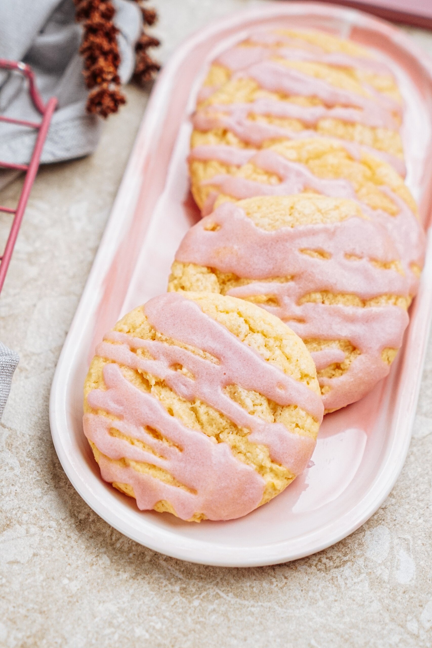 Pink glazed cookies on a rectangular white and pink dish.