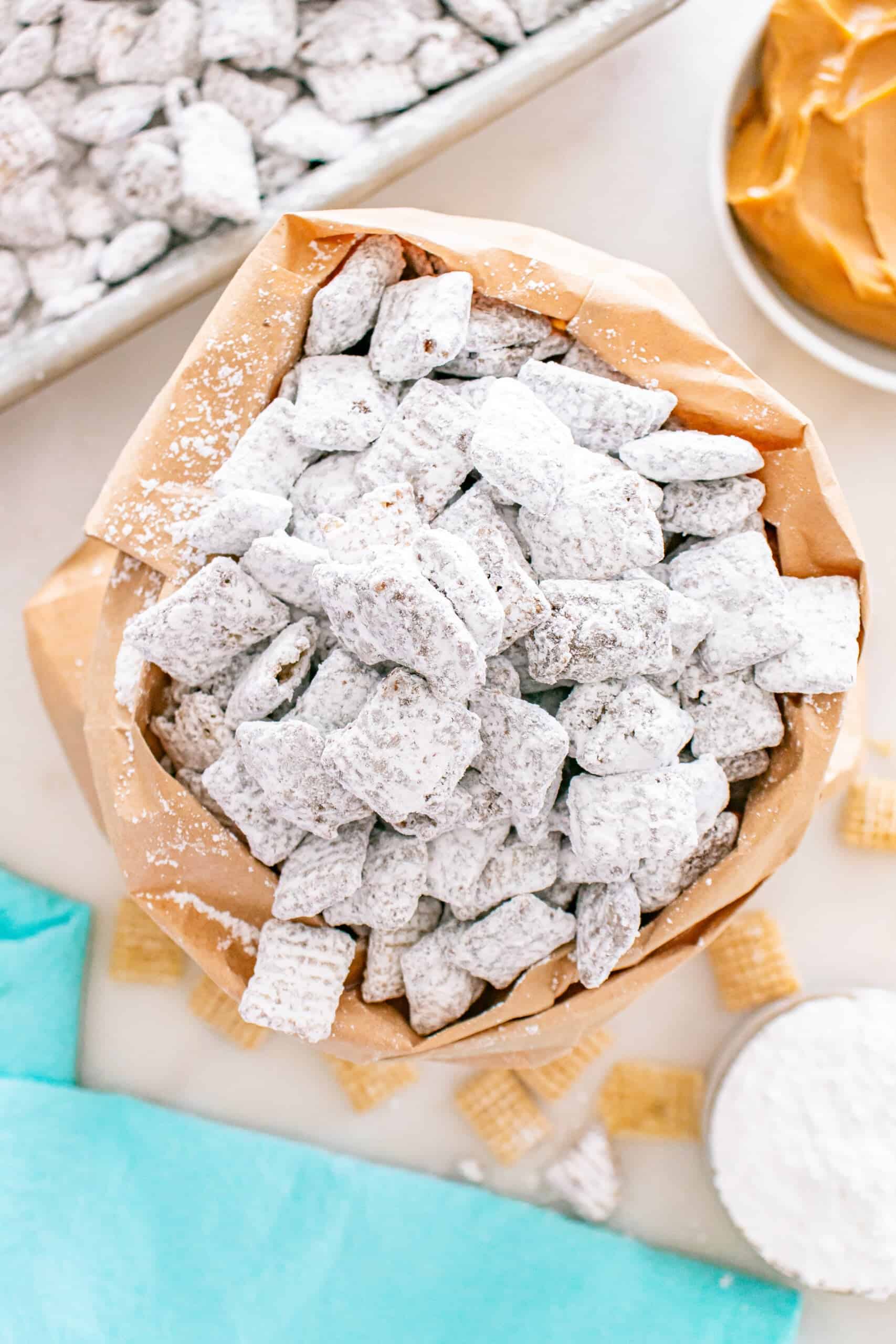 Bag of puppy chow coated in powdered sugar with Chex cereal pieces.