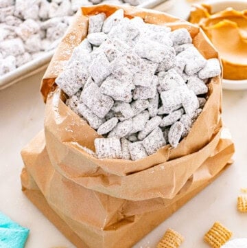 Bag of puppy chow coated in powdered sugar with Chex cereal pieces.
