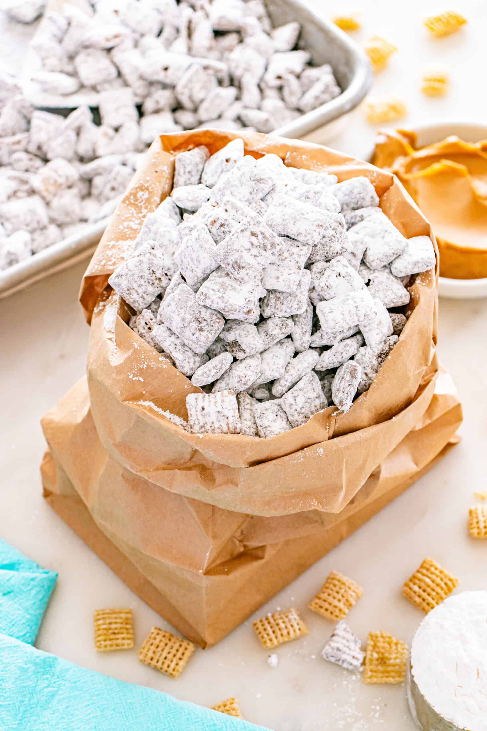 Bag of puppy chow coated in powdered sugar with Chex cereal pieces.