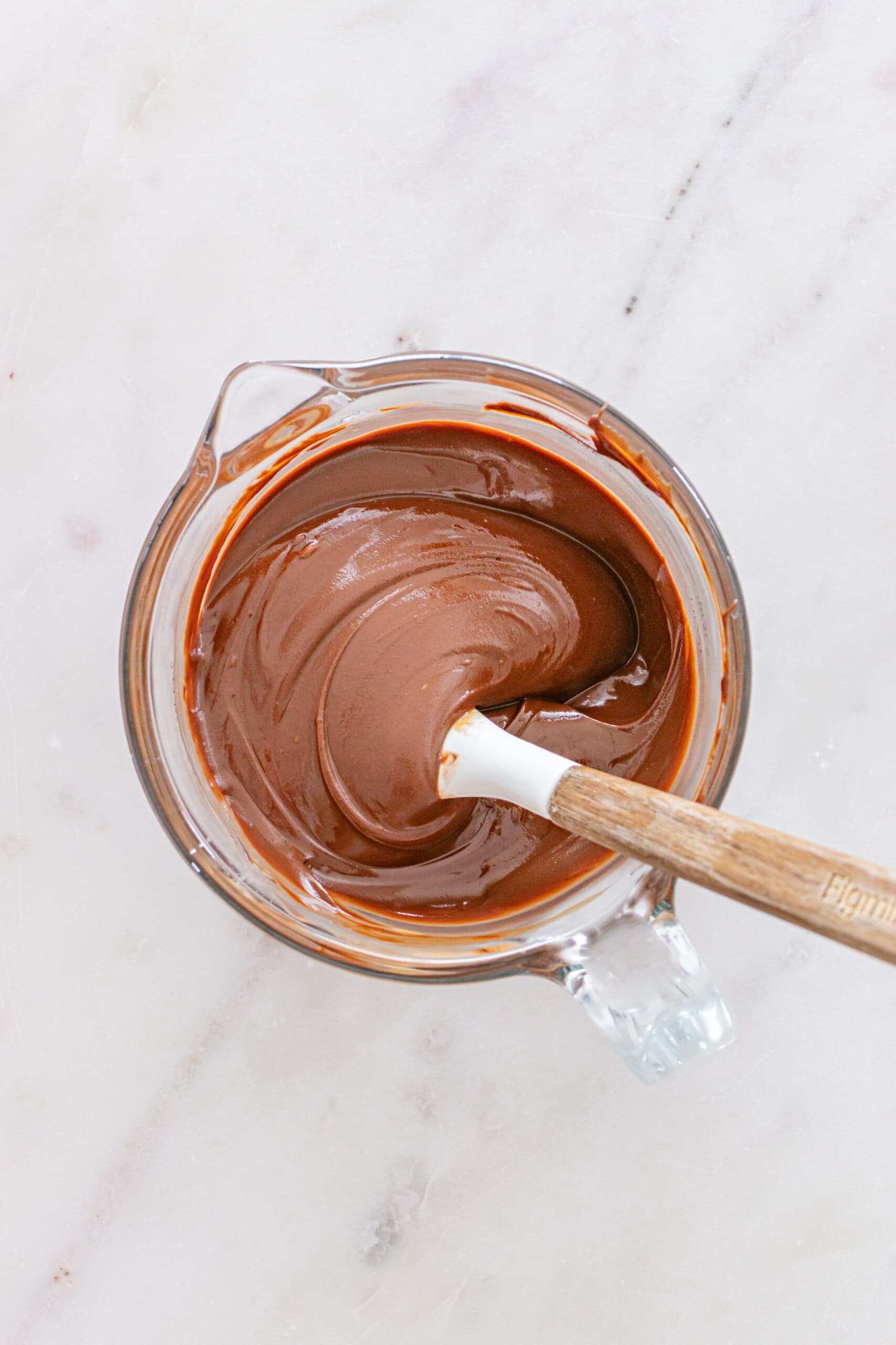 Melted chocolate mixture in glass cup.