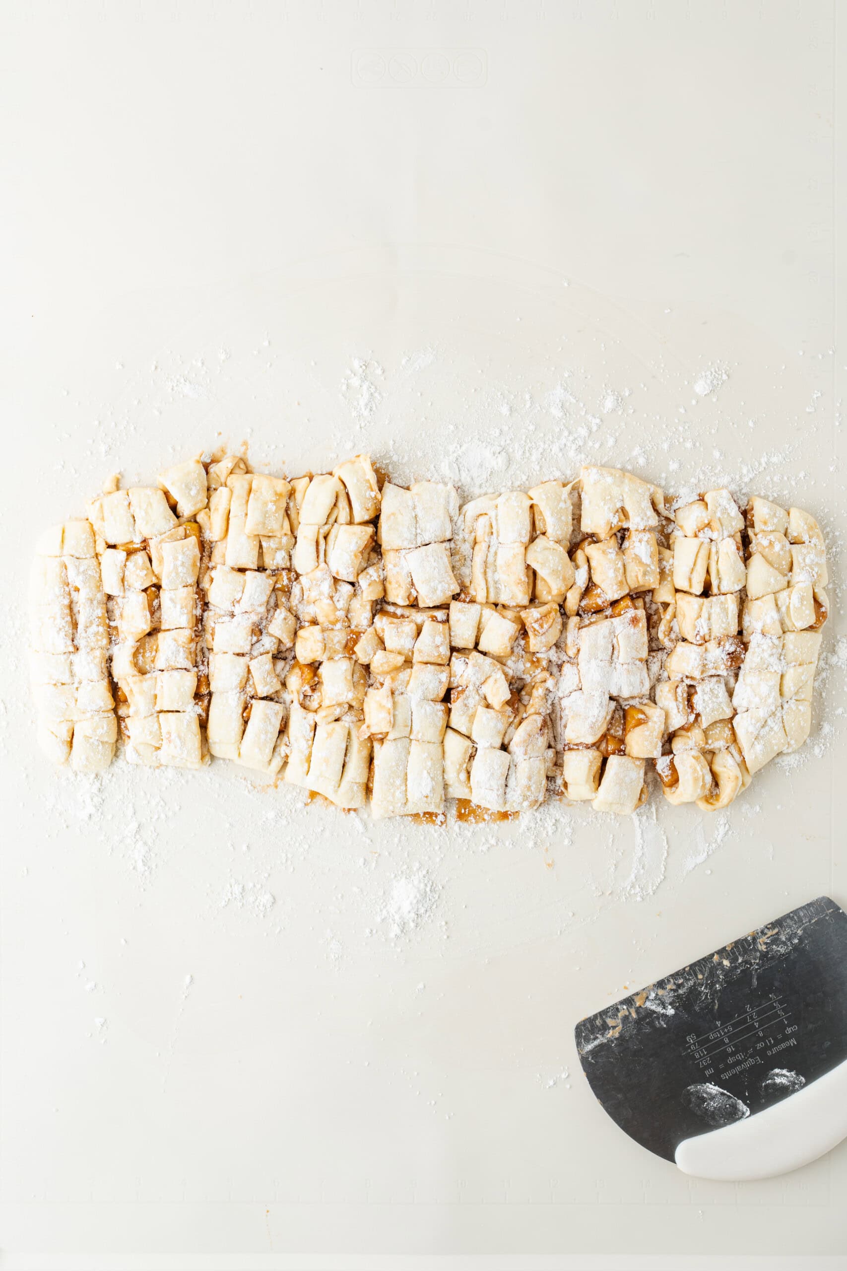 Chopped apple fritter dough pieces dusted with flour.
