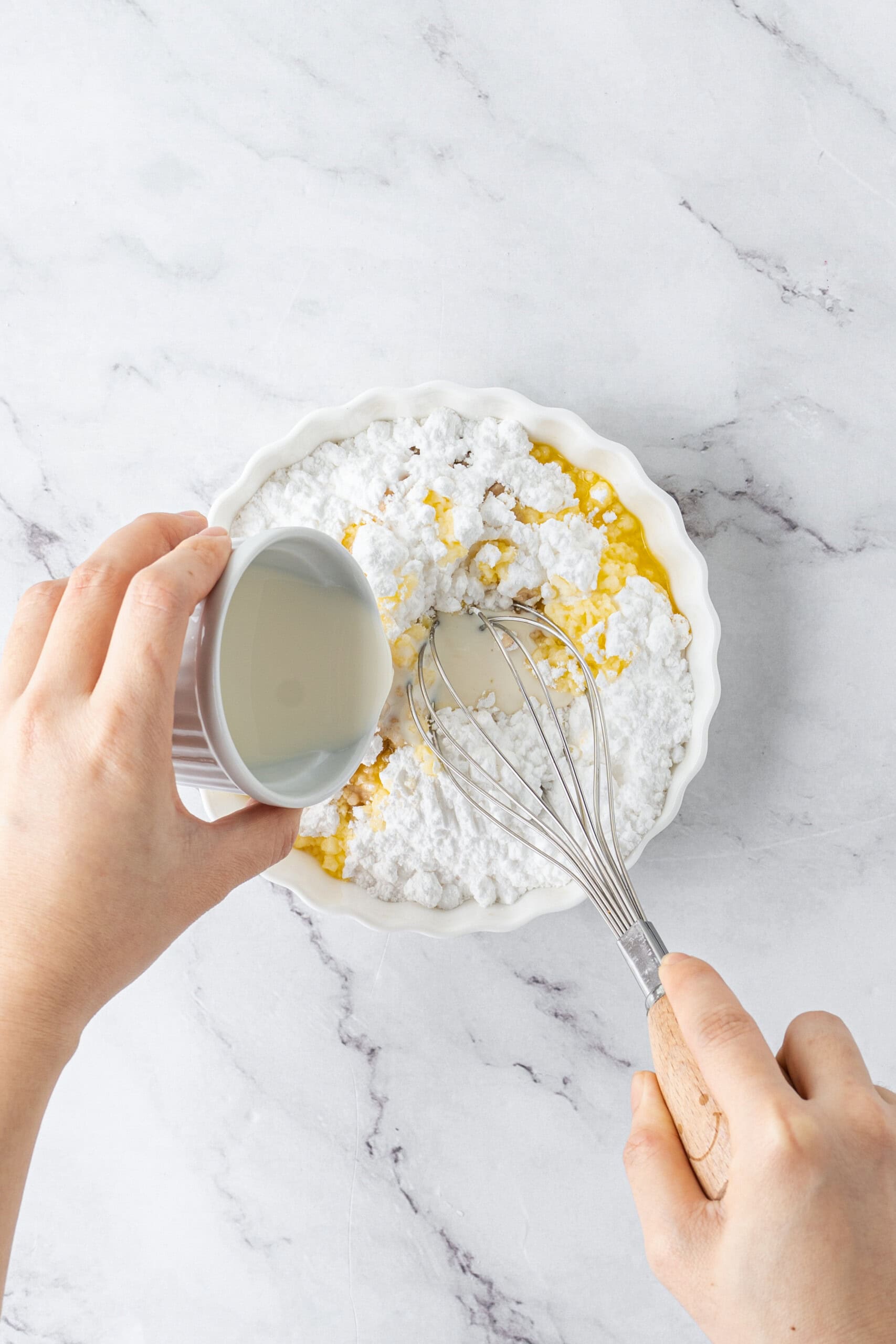 Making glaze with powdered sugar, melted butter, and milk.