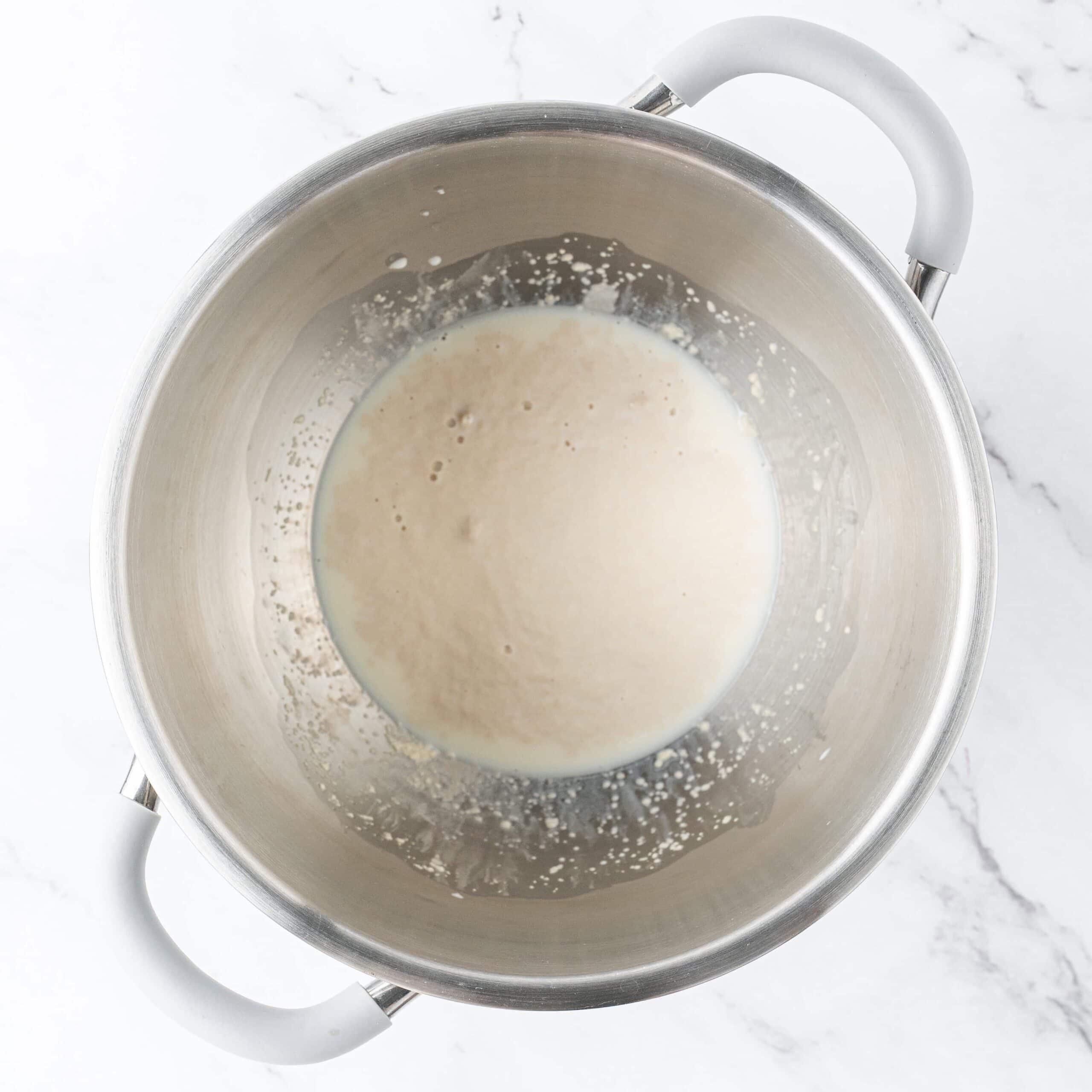 Yeast and milk mixture in a mixing bowl.