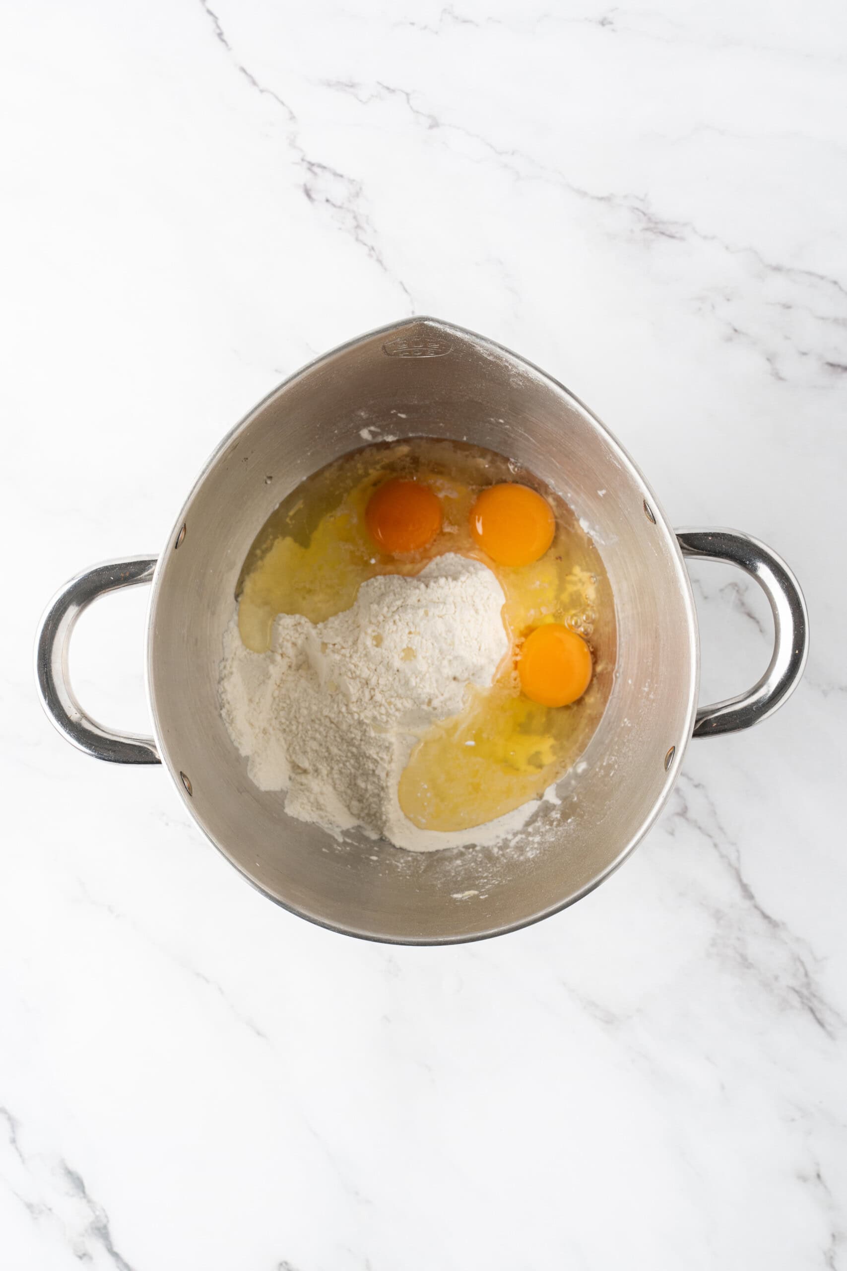 Mixing bowl with the dry ingredients and egg ready to be combined for donut hole dough.