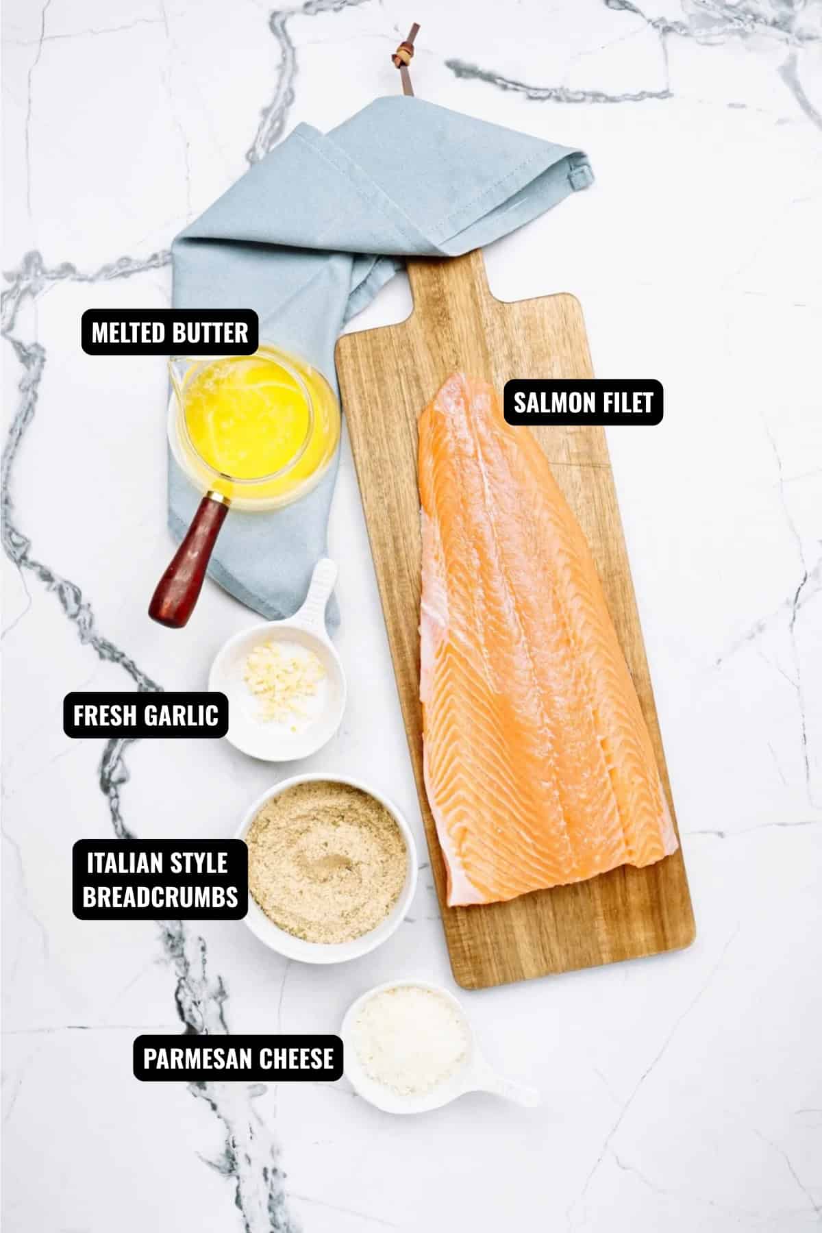 ingredients for baked salmon recipe including salmon fillet, butter, garlic, italian style breadcrumbs, and parmesan cheese.