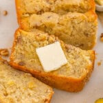 Banana nut bread sliced and served with butter, featuring a moist texture and crunchy walnuts.