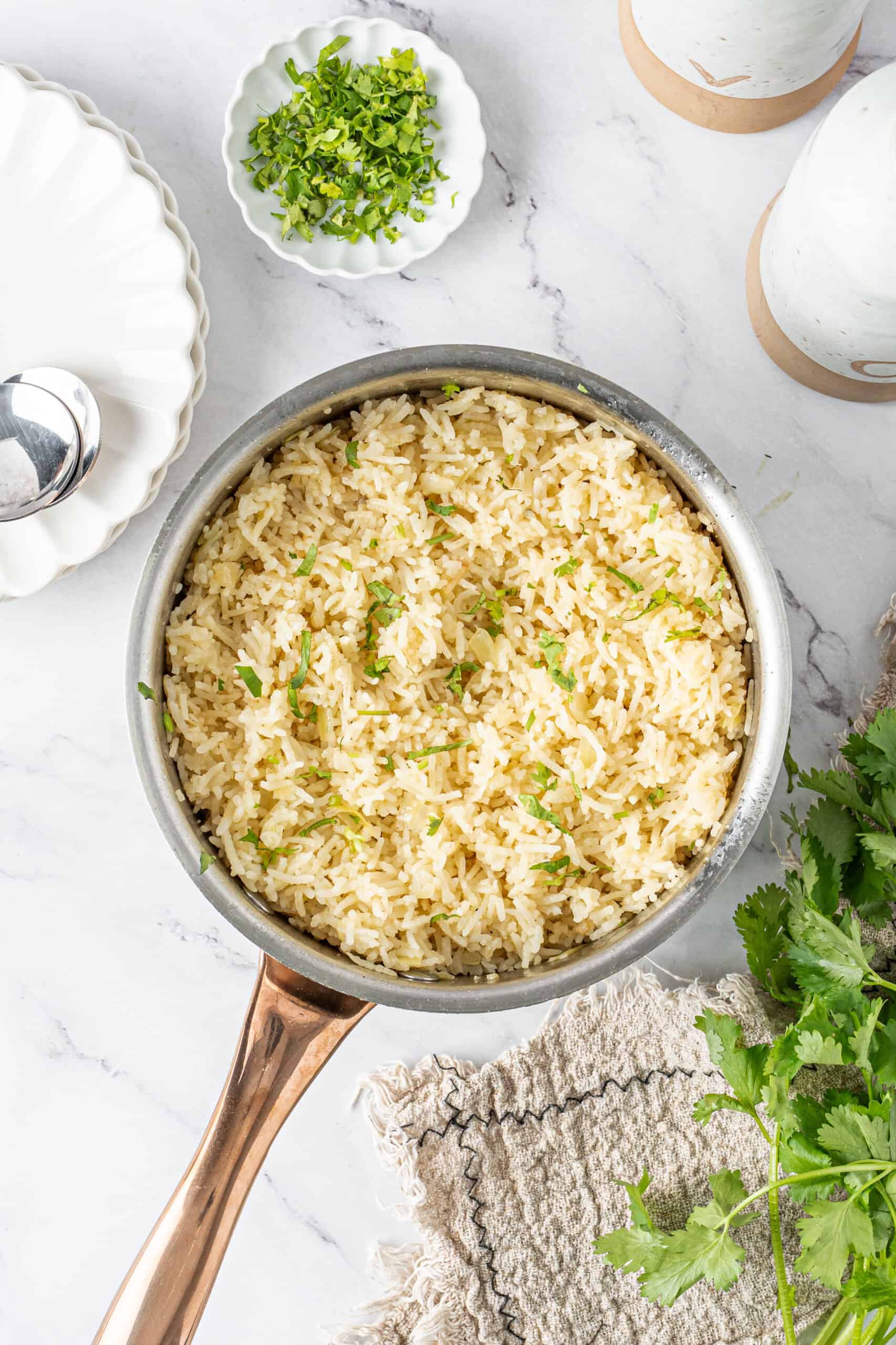 Fluffy butter rice in a skillet, garnished with fresh parsley and ready to serve.
