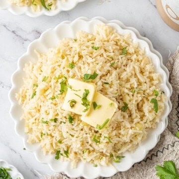 Bowl of fluffy butter rice topped with butter and fresh parsley
