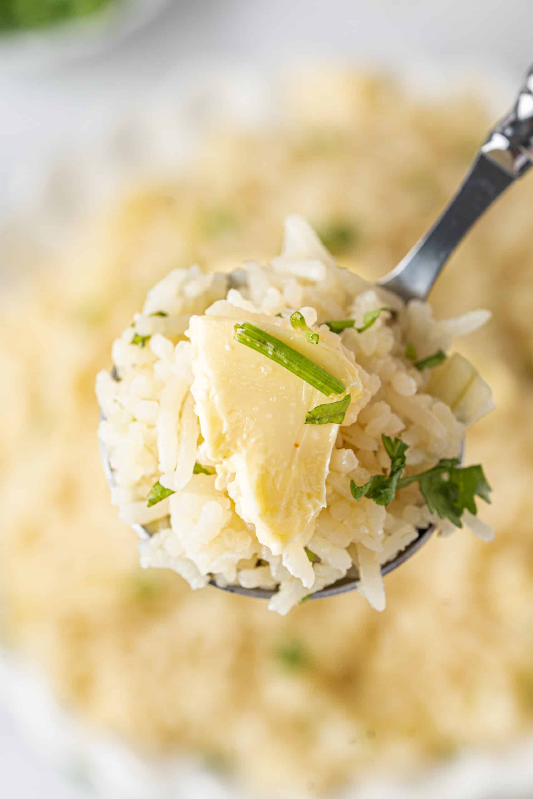 Spoonful of fluffy rice with melting butter and fresh parsley