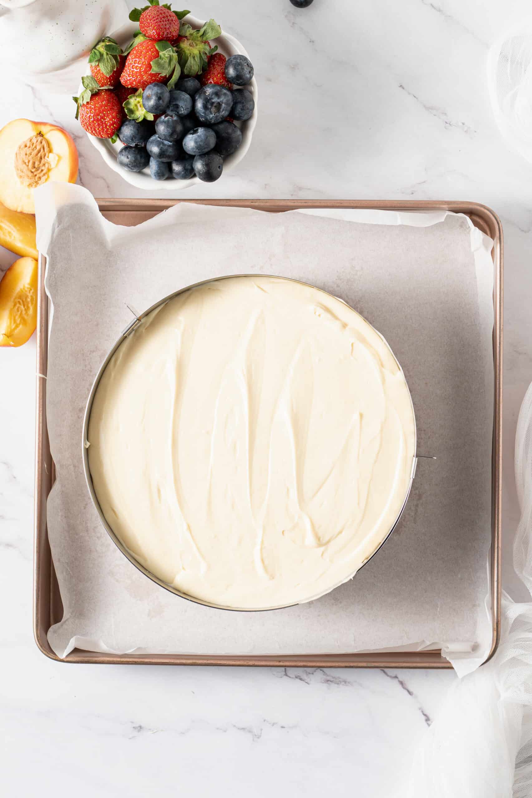 Cheesecake filling spread evenly over the prepared graham cracker crust, ready to bake.