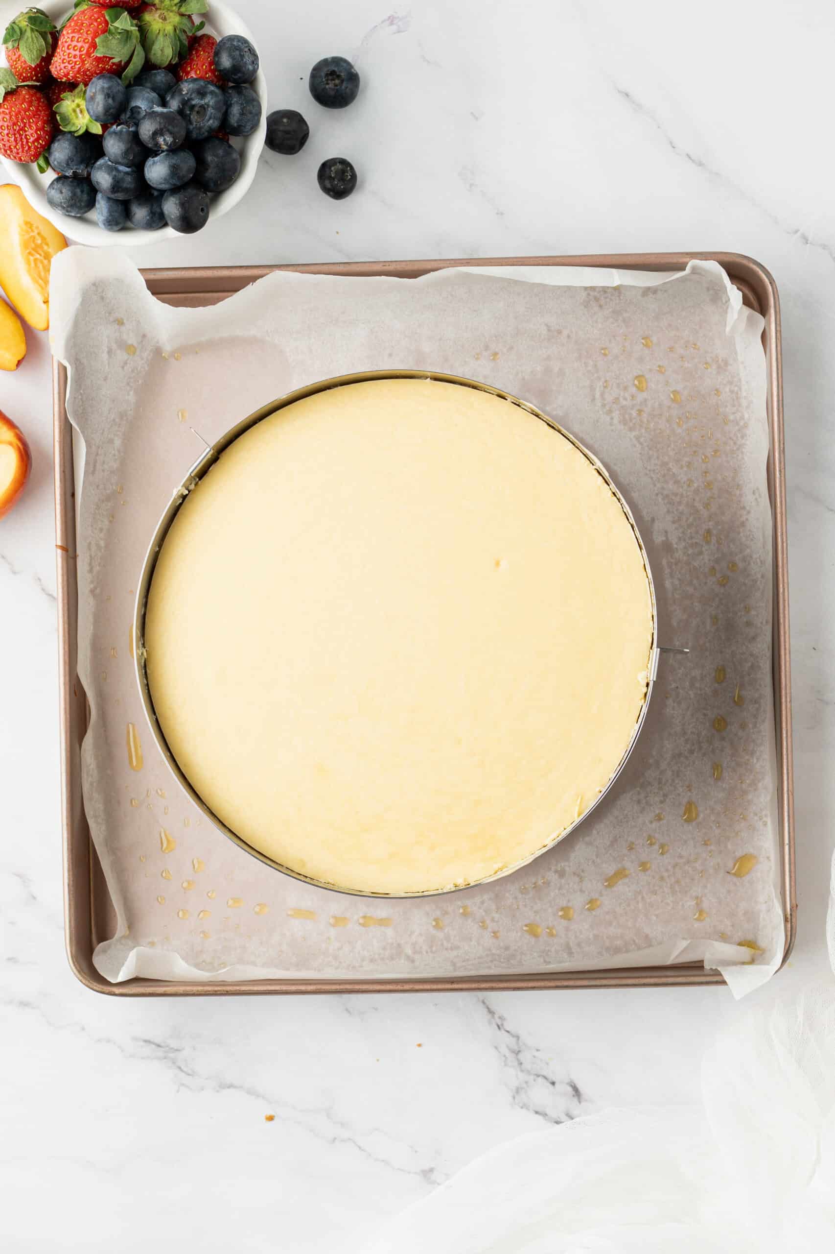 Baked cheesecake with a lightly golden top, cooled in the pan before chilling.