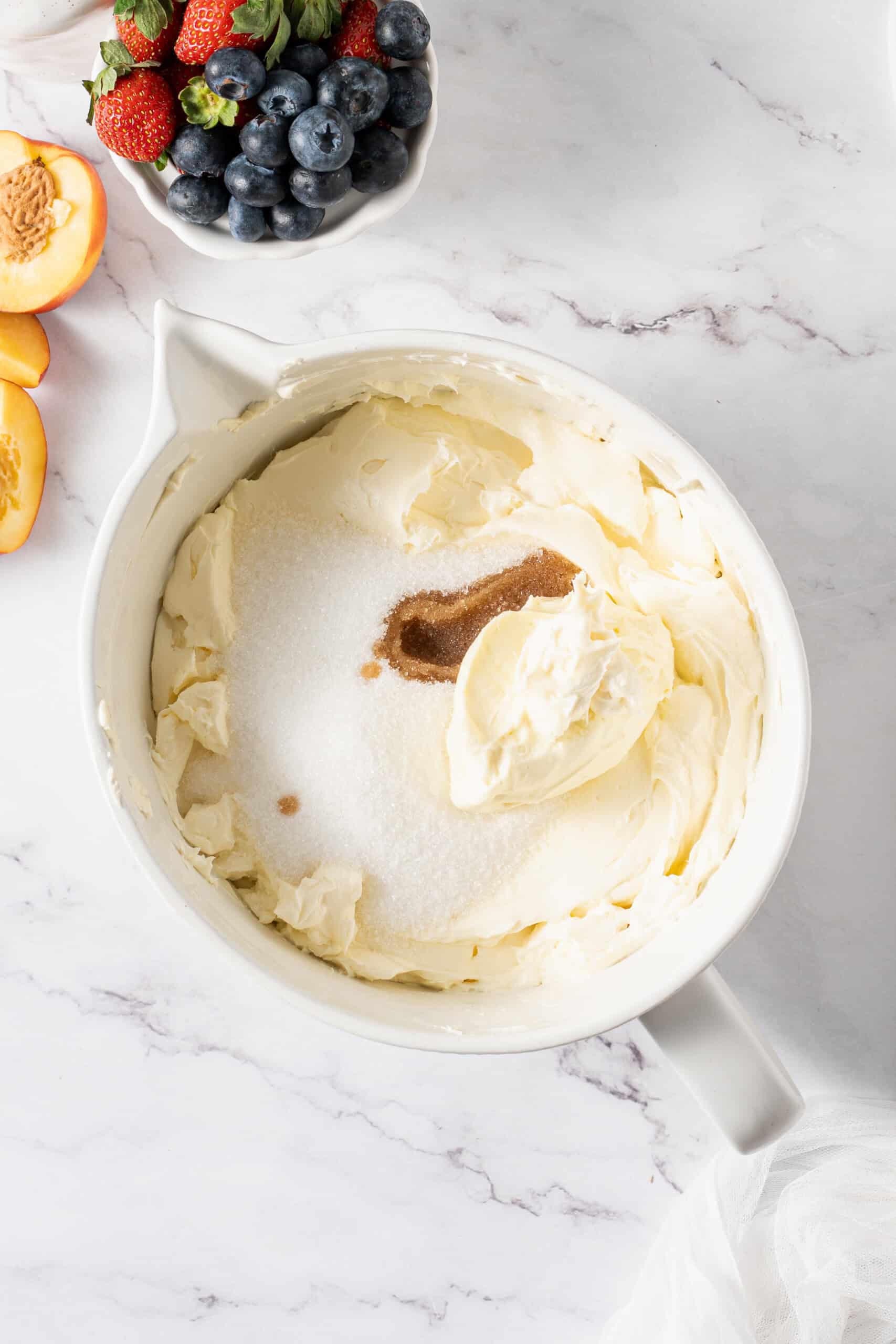 Cream cheese, sugar, sour cream, and vanilla extract in a bowl
