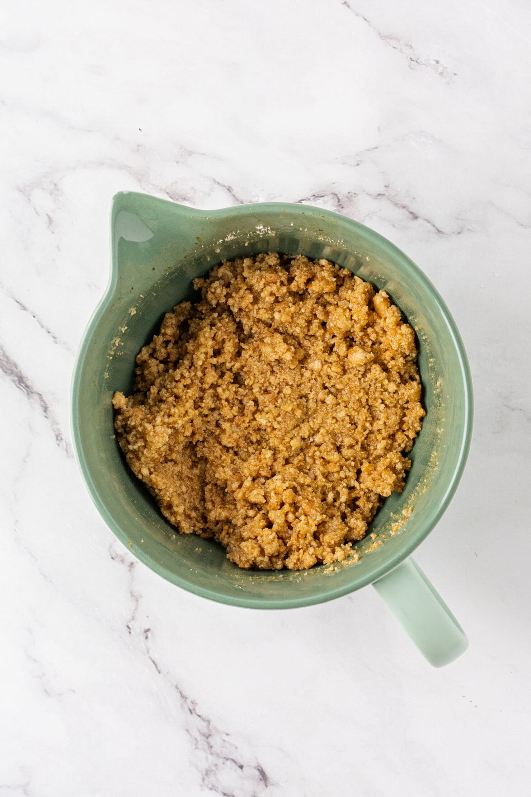 Mixed graham cracker crust in a mixing bowl