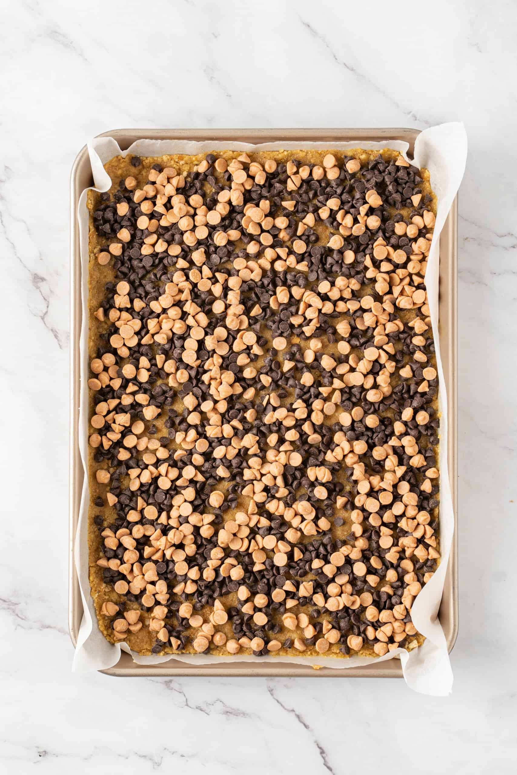Butterscotch chips and chocolate chips layered over a graham cracker crust