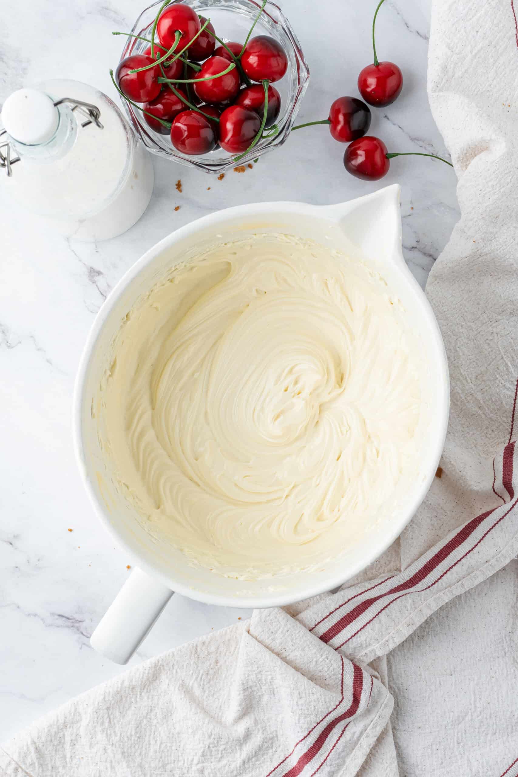 Smooth no-bake cheesecake filling mixed until light, creamy, and lump-free in a white mixing bowl.
