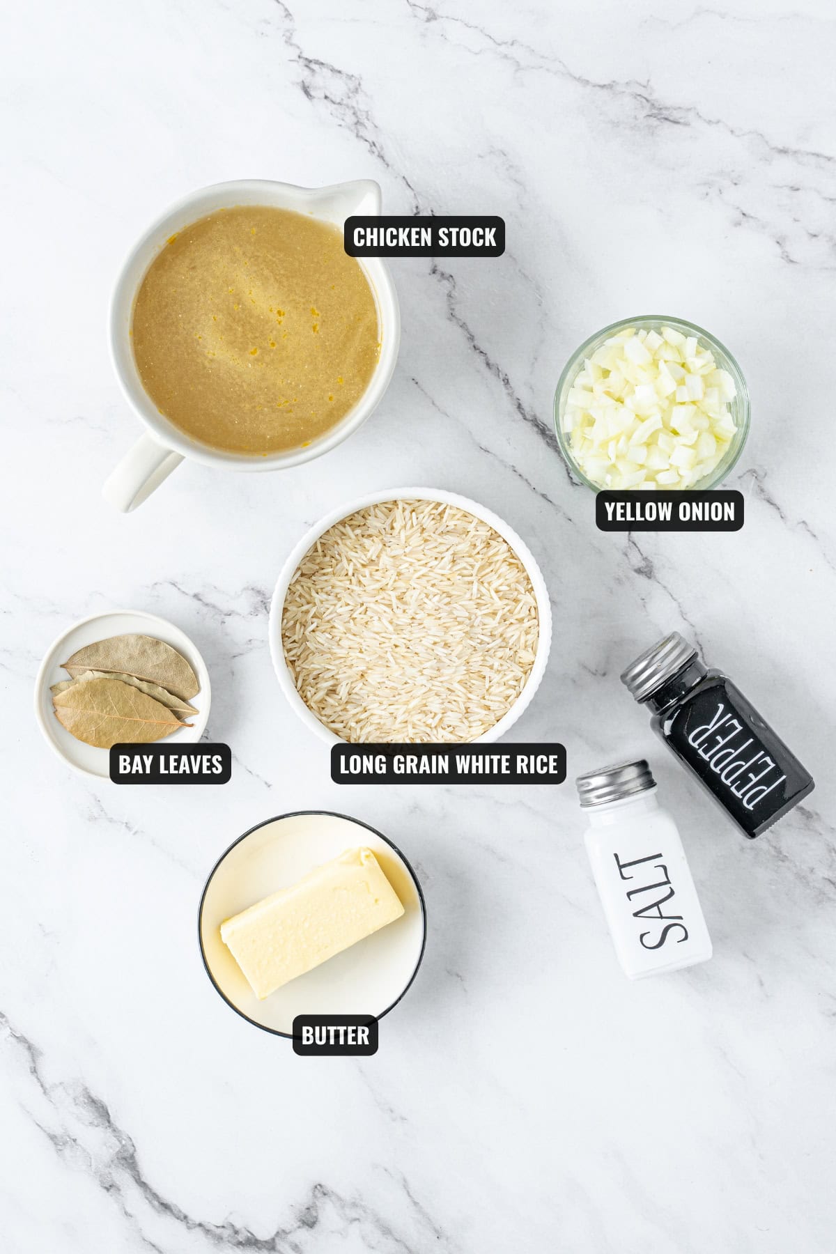 ingredients for butter rice recipe including long grain white rice, yellow onion, bay leaves, butter, and chicken stock.